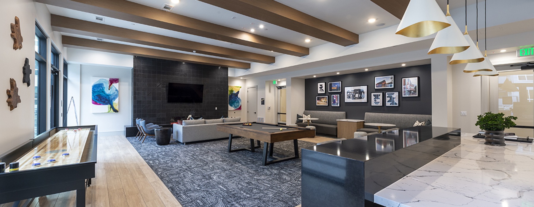 social lounge area with high beams and activities like a shuffleboard and pool